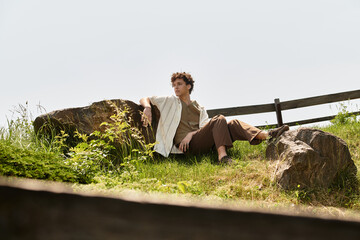 Young man embraces summer style while relaxing in a green park surrounded by nature