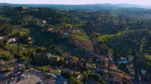 Stunning golden hour drone footage sweeping over Florence&rsquo;s lush Tuscan hills and cypress lined villas near Piazzale Michelangelo, revealing olive groves, historic towers and winding roads, Italy.