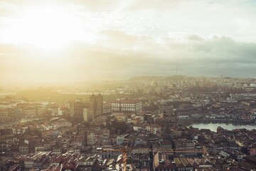 Travelers explore the stunning cityscape of Porto at golden hour, observing notable architecture such as the Porto Cathedral and the Dom Luis I Bridge