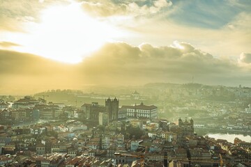 Dawn over Porto showcases classic architecture. Clérigos Tower, Ribeira, and São Bento Station appear as diverse travelers experience the city's timeless beauty