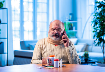 Old Indian man with medication calling doctor from home for health-related query