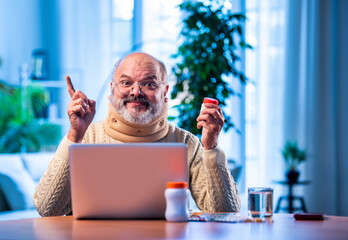Elderly Asian man researching medicine dosage online at home using laptop