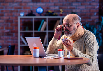 Elderly Asian man researching medicine dosage online at home using laptop