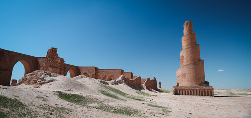 Historic brick tower and ruins in Abu Dulaf Iraq under clear blue sky