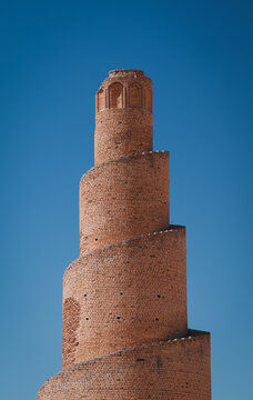 Spiral brick minaret standing tall against clear blue sky in Abu Dulaf Iraq