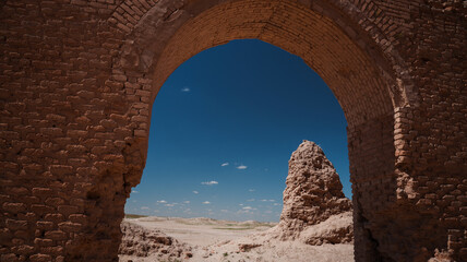 Historic ruins frame a vast desert landscape in Abu Dulaf, Iraq during midday
