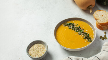 Creamy butternut squash soup with pumpkin seeds and sesame. Copy space