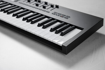 One portable MIDI keyboard on white table, closeup