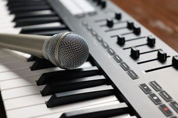 MIDI keyboard and microphone on table, closeup