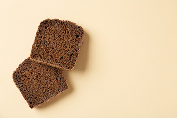 Pieces of fresh rye bread on beige background, top view. Space for text