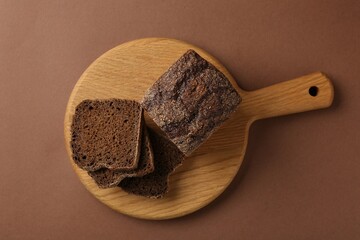 Pieces of fresh rye bread on brown background, top view