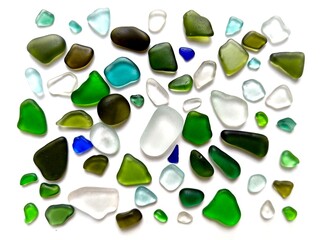 Sea glass pieces in various colors arranged on a white background, showcasing natural texture and sea-worn beauty.