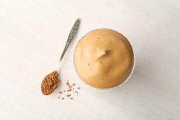 Delicious dalgona coffee in glass and granules on light table, flat lay