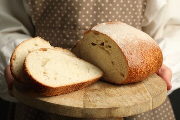 Woman with pieces of fresh bread, closeup
