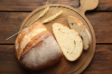 Pieces of fresh bread and spikes on wooden table, flat lay