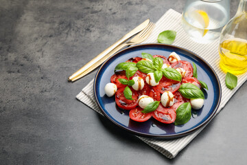 Tasty salad Caprese served with balsamic vinegar on grey table, closeup. Space for text