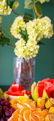 Tropical fruit charcuterie board, tray plate, light white floral background. Vegan food concept.
