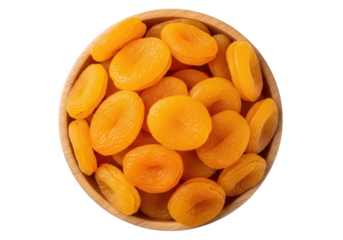 Overhead view of dried apricots overflowing a wooden bowl against fruit food