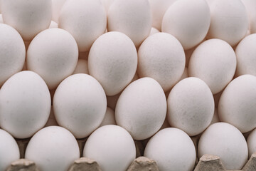 Chicken eggs with while eggshell in a cardboard packaging. Heap of chicken eggs from village. breakfast. Eggs on the counter.