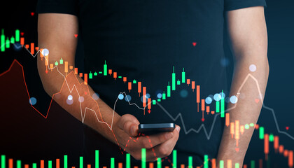 Man holding smartphone with stock market chart overlay on dark background, showing financial crisis and market crash concept visually represented.
