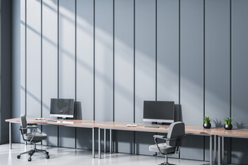 Modern empty office interior with sleek desks, minimalist design, and sunlight casting shadows on...