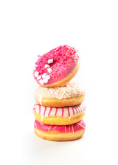 Colorful stack of delicious donuts with frosting and sprinkles on a white background