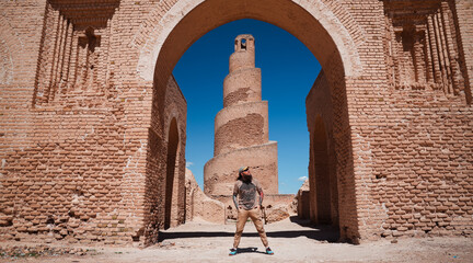 Tourist admires Iraqs ancient brick architecture under clear blue skies