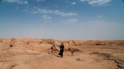 Exploring the vast desert landscape of Iraq with a child during a sunny day