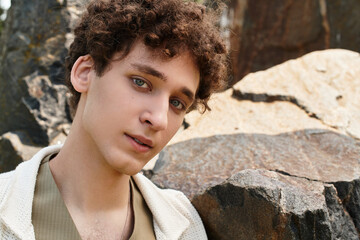 Stylish young man enjoying a sunny day in a vibrant green park with a relaxed vibe