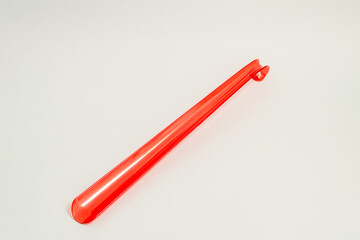 Shoehorn, red shoe spoon easy slip on, on grey background