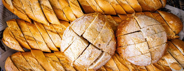 Fresh fragrant breads on the table. Bakery food concept panorama or wide banner photo background