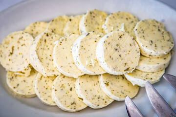 Festa cheese slices, feta garlic, herbs and spices background. Side view, selective focus.
