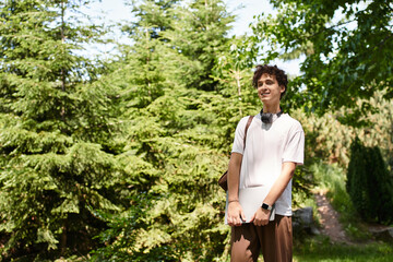 Young man enjoying a sunny day in a vibrant green park while dressed casually