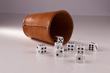 A random arrangement of dice and a puzzle cup, captured after the dice have been cast.