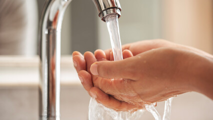Woman washing her hands in the bathroom