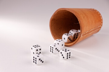A random arrangement of dice and a puzzle cup, captured after the dice have been cast.