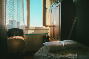 An old bedroom with an embroidered curtain on the window