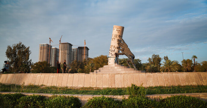 Baghdad, Iraq - March 22, 2025: Hand sculpture in Baghdad symbolizes strength, blending urban development and nature