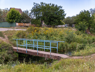 A small bridge over a small stream in a grassy field