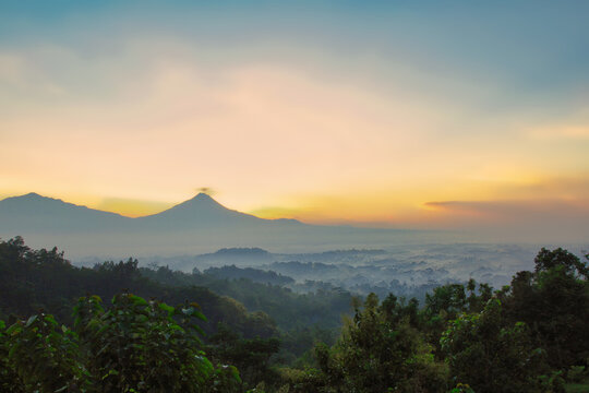 Sunrise over Borobudur Temple with Mount Merapi in the background, viewed from Setumbu Hill, Indonesia.