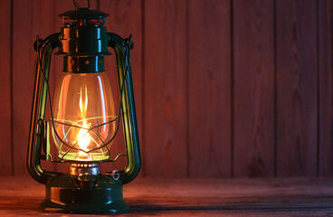 One vintage kerosene lantern on wooden table, space for text