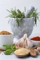 Different aromatic spices on grey table against light background, closeup