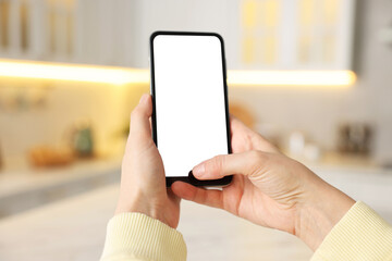 Woman using modern smartphone at home, closeup