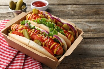 Tasty hot dogs served on wooden table, closeup