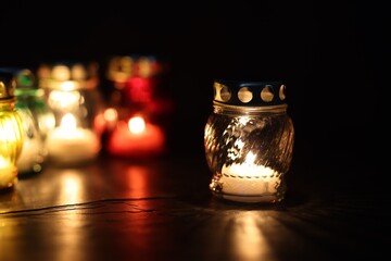 Many grave candles on black background, closeup