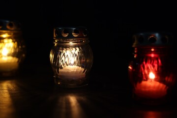 Many grave candles on black background, closeup