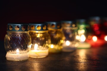 Many grave candles on dark background, closeup