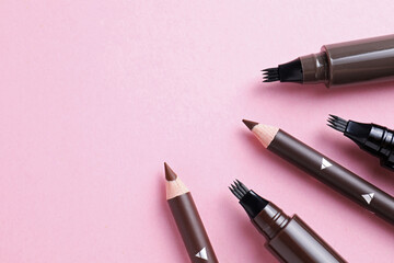 Different eyebrow pencils on pink background, closeup. Space for text