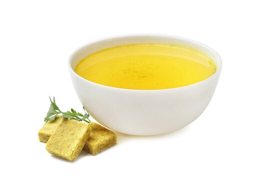 Aromatic bouillon cubes, broth and parsley isolated on white