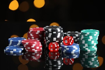 Casino chips and dice on mirror surface against blurred lights, closeup